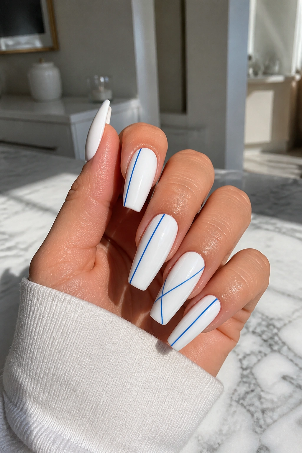 Close-up of porcelain stripe nails with blue lines on a white base