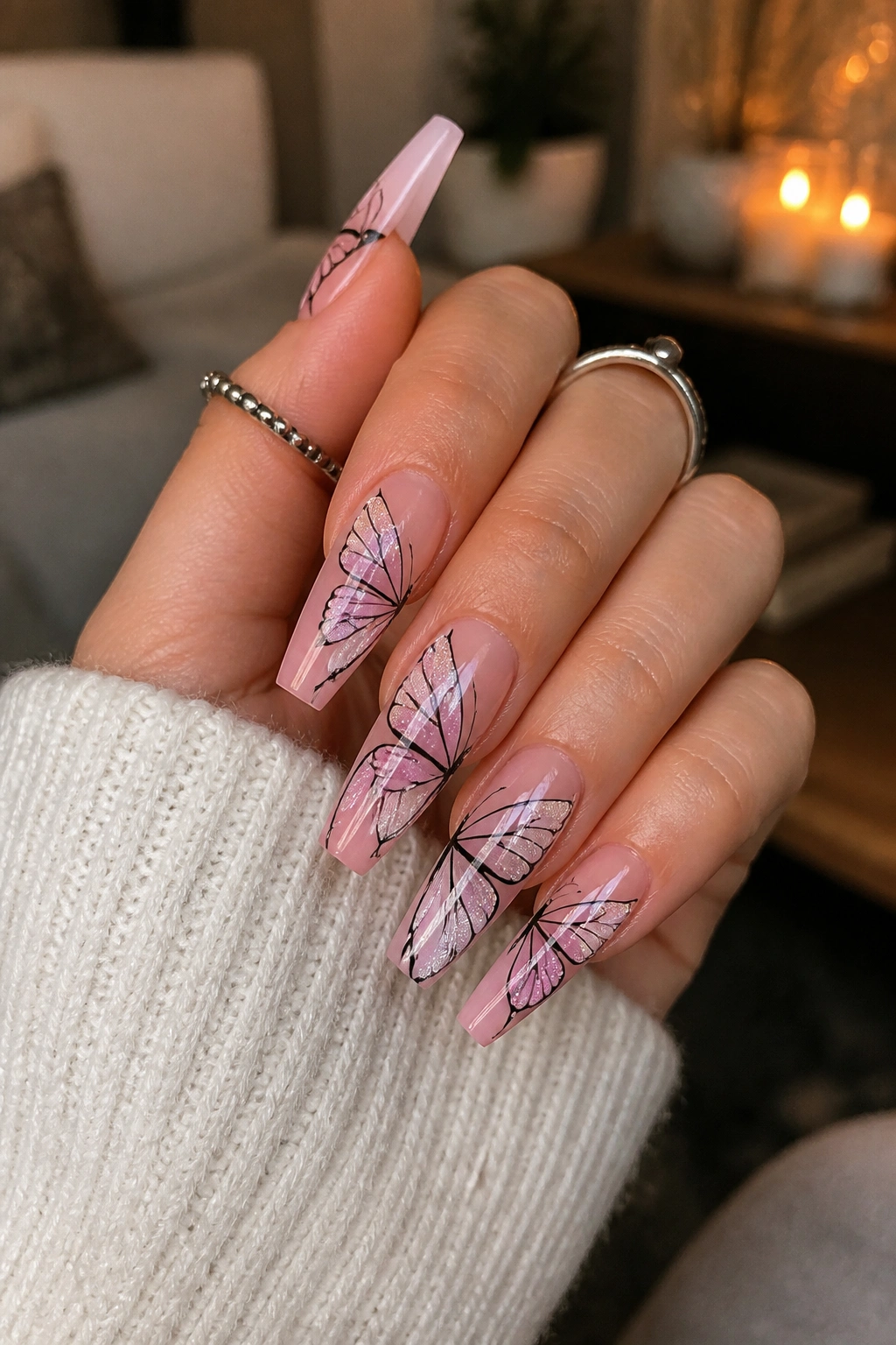 Close-up of press-on butterfly coffin nails with airbrushed fade on a real hand
