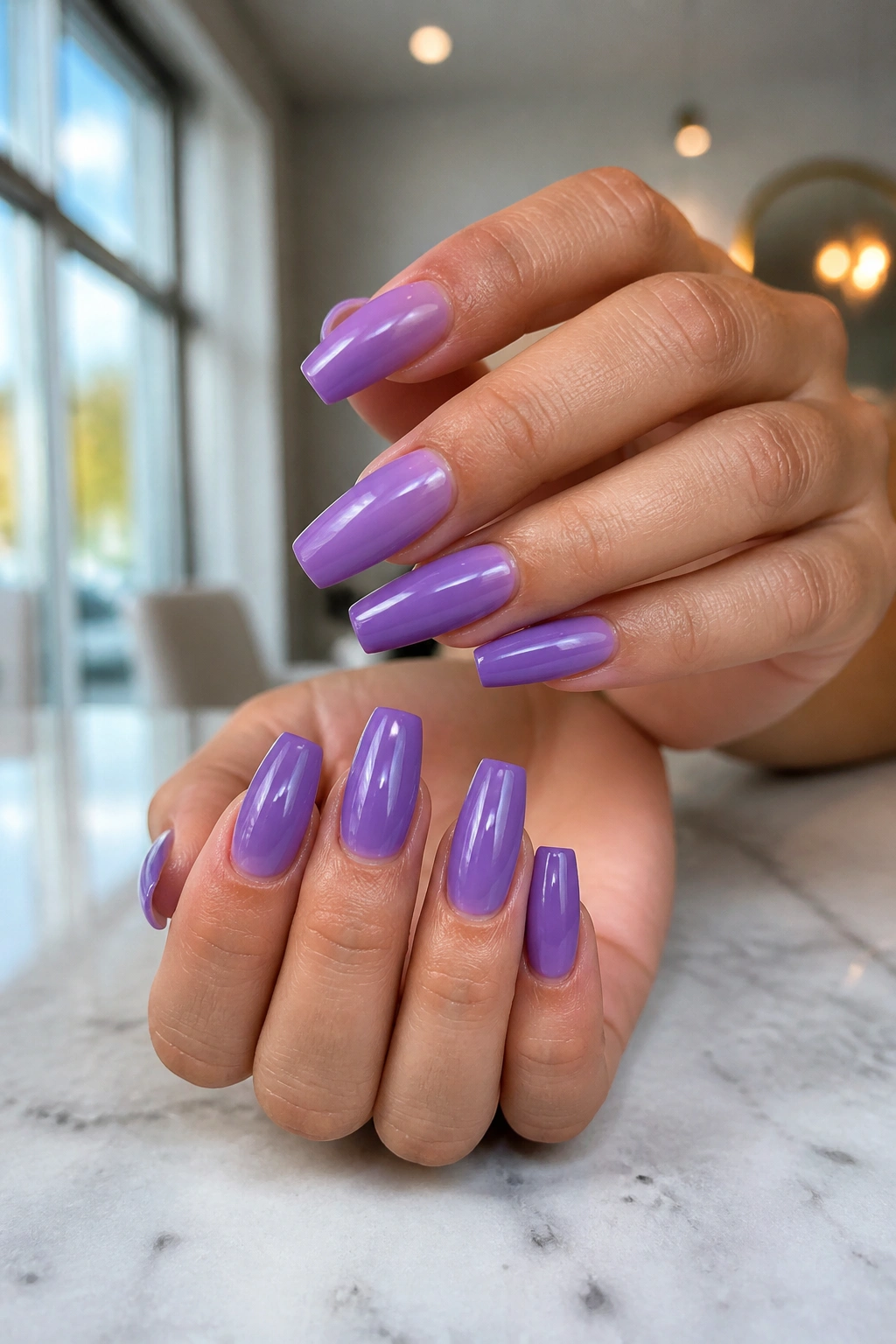 Close-up of medium-length coffin nails in cool purple on real hands.
