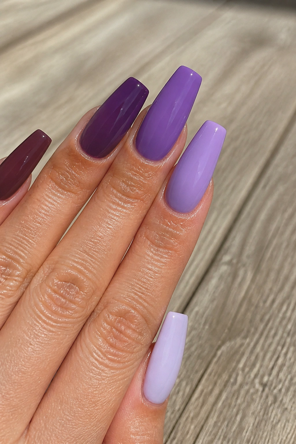 Five-nail purple skittle coffin nails gradient on a real hand.