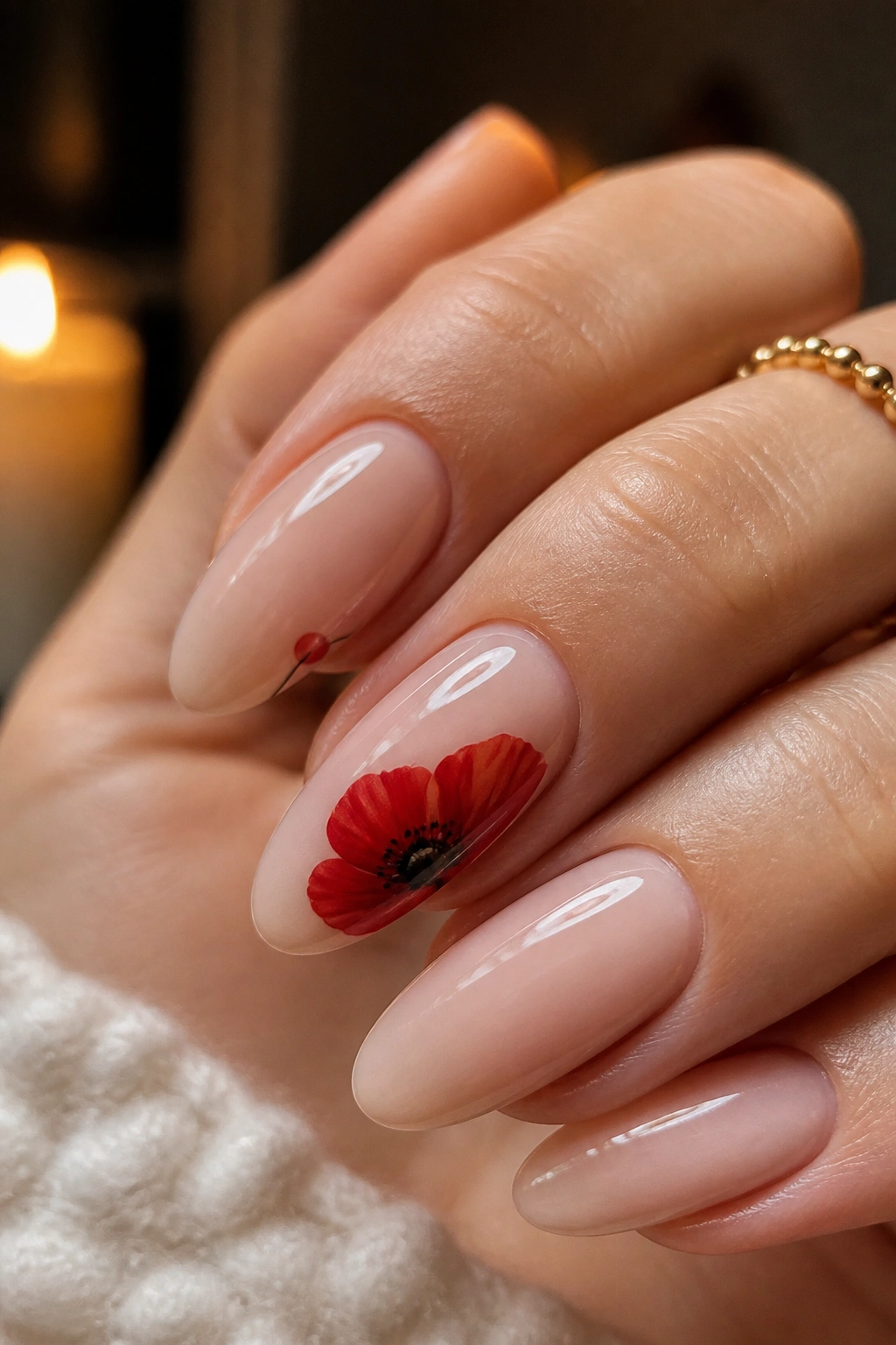 Almond nails with bold red poppy focal bloom on nude base