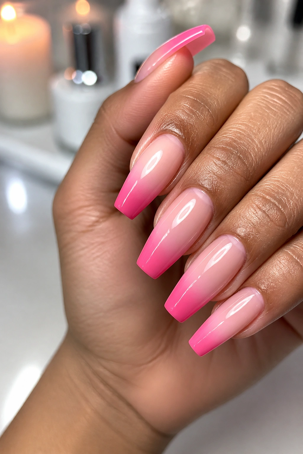 Close-up of reverse-tip pink ombre coffin nails with color at the free edge on a real hand