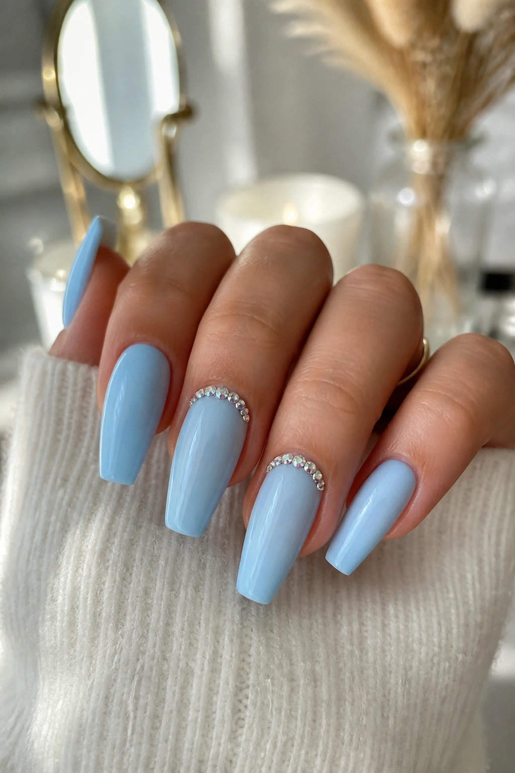 Nails with rhinestone crescent at the cuticle on a blue coffin manicure