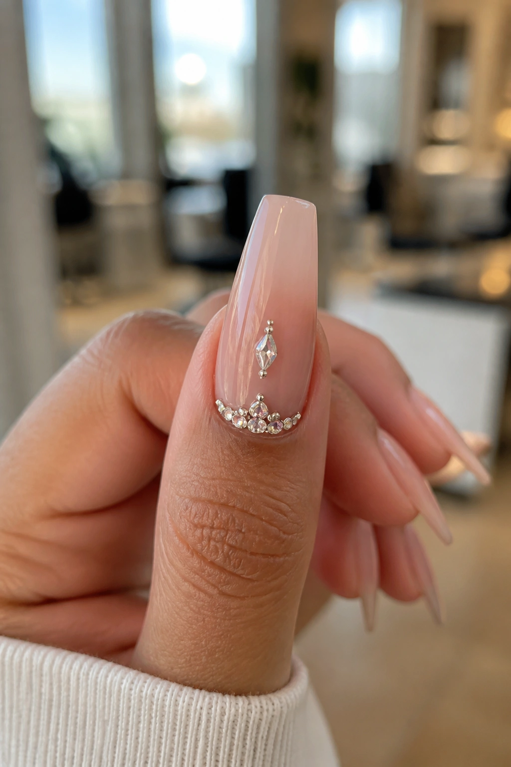 Close-up of rhinestone ballerina coffin nail with center stone and cuticle cuff on real hand