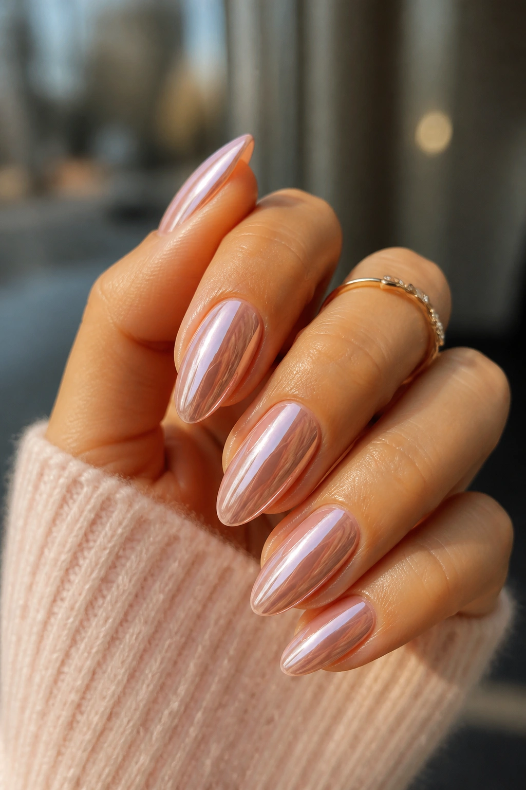 Close-up of a real hand with rose chrome over soft pink almond nails