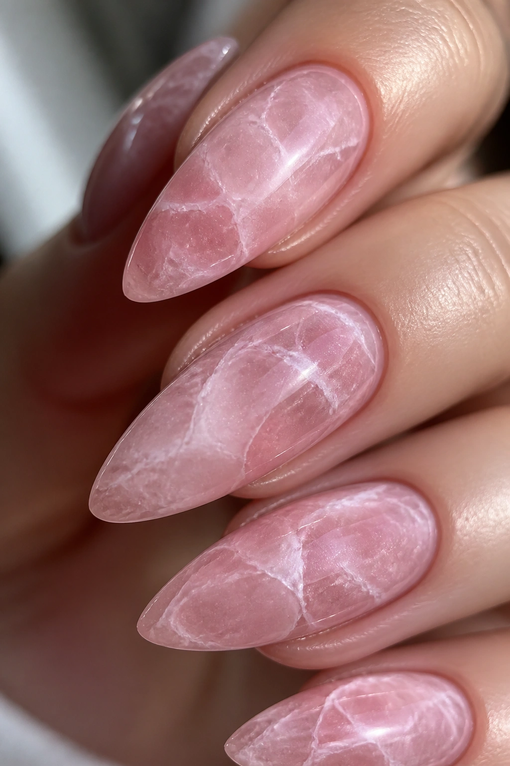 Close-up of almond nails in rose quartz marble