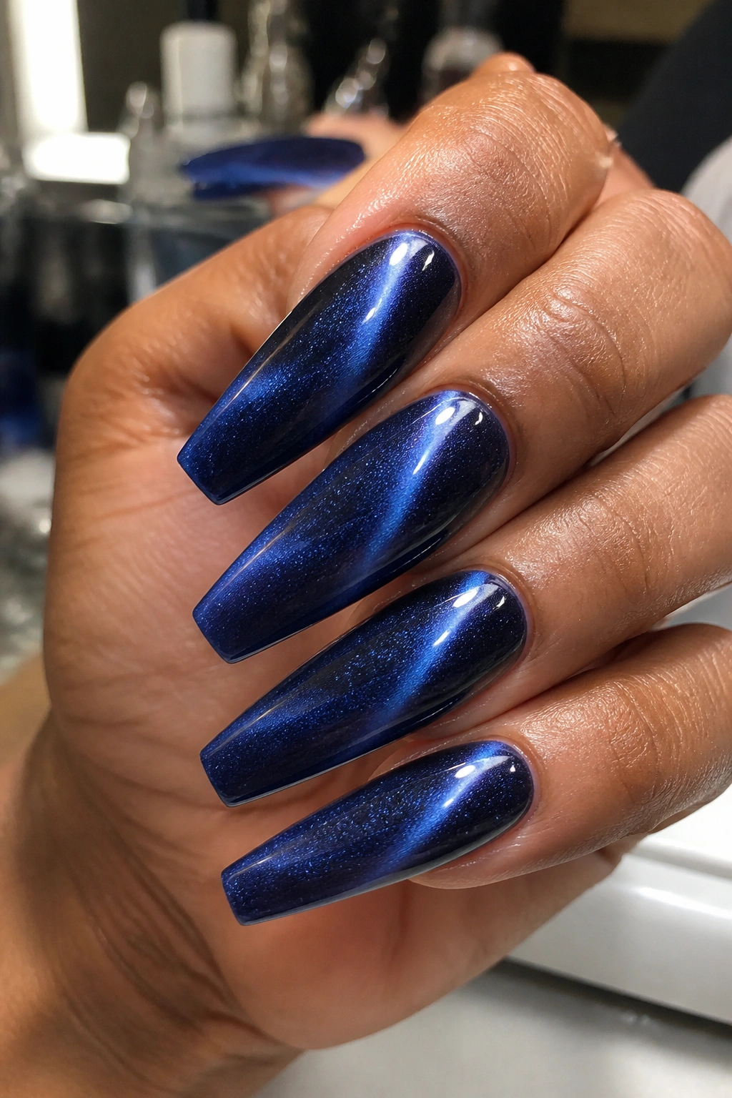 Close-up of coffin nails with sapphire cat-eye velvet finish