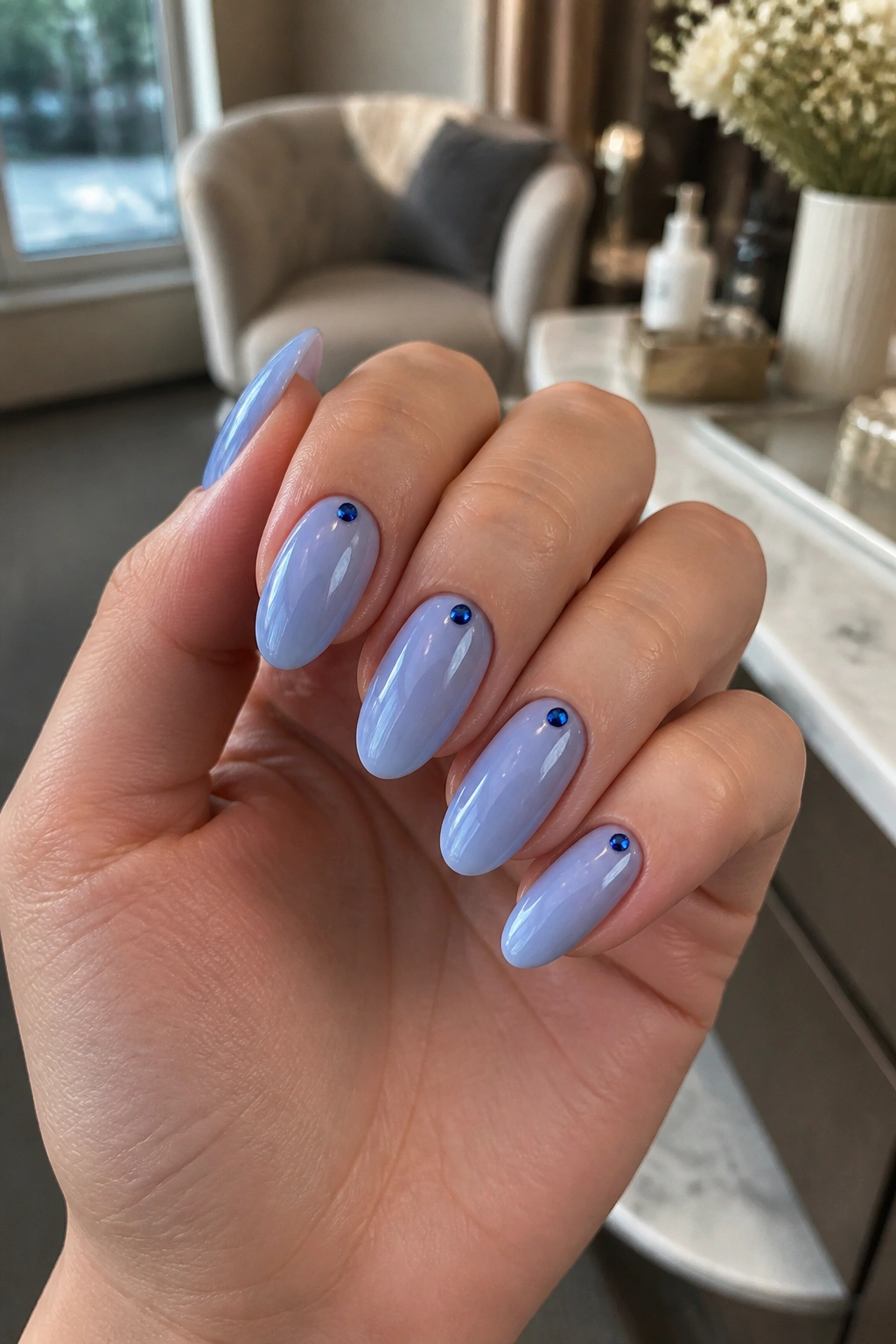 Almond nails with tiny sapphire cuticle dots on a real hand