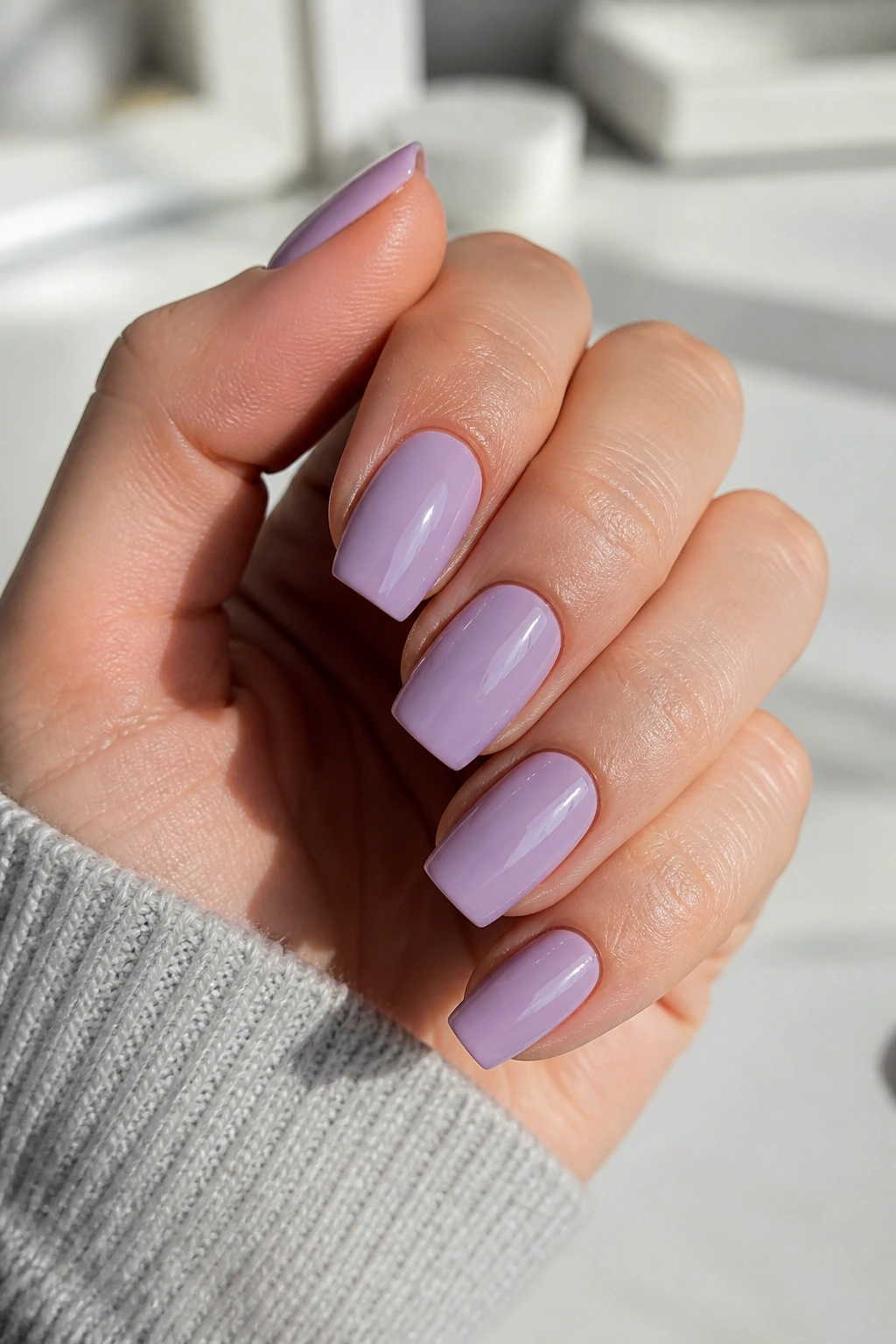 Close-up of short dusty lavender coffin nails on a real hand