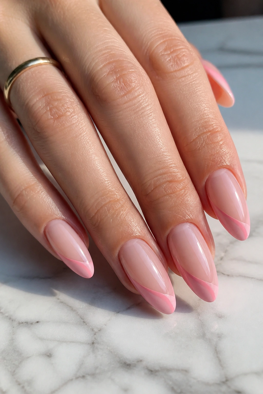 Almond nails with side-swoop pink French tips on a hand