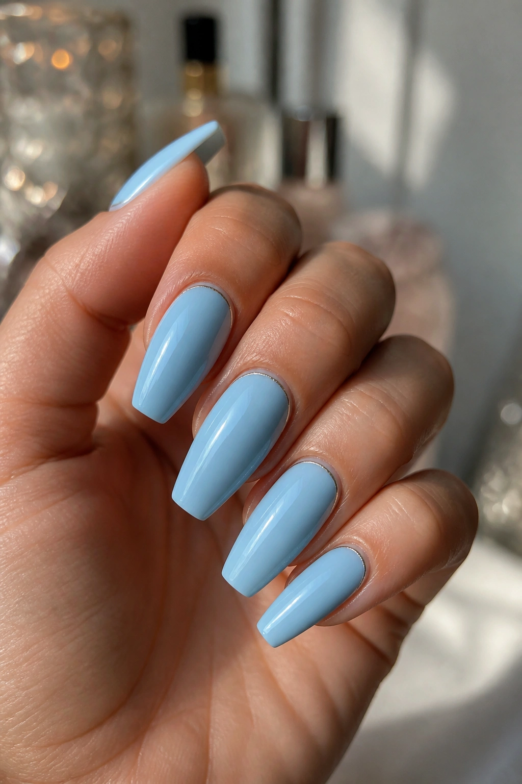 Close-up of real hand with light blue coffin nails featuring silver cuticle lines