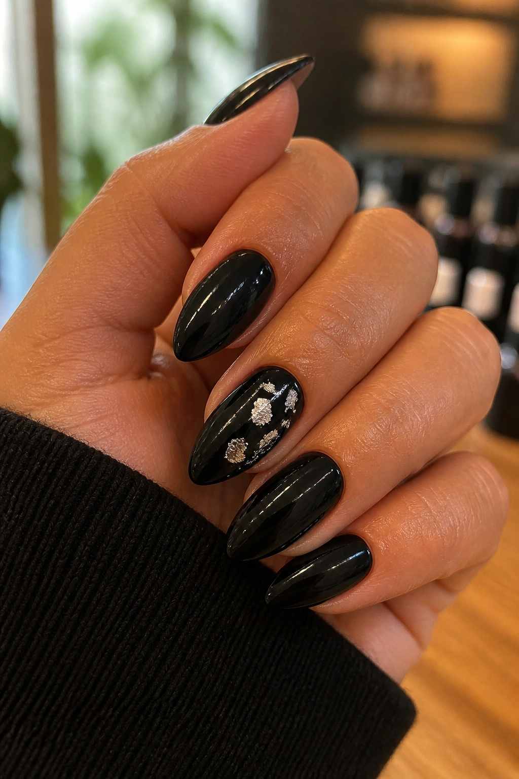 Almond nails with black polish and silver foil on accent nail