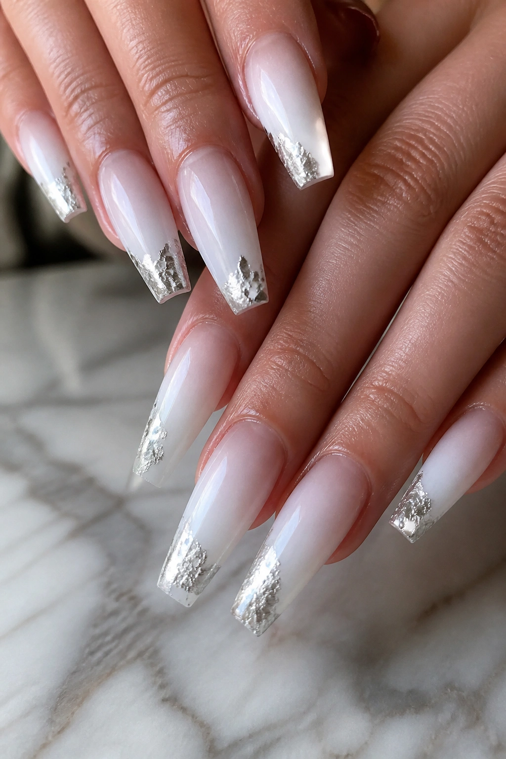 Close-up of coffin nails with silver foil tips on a real hand