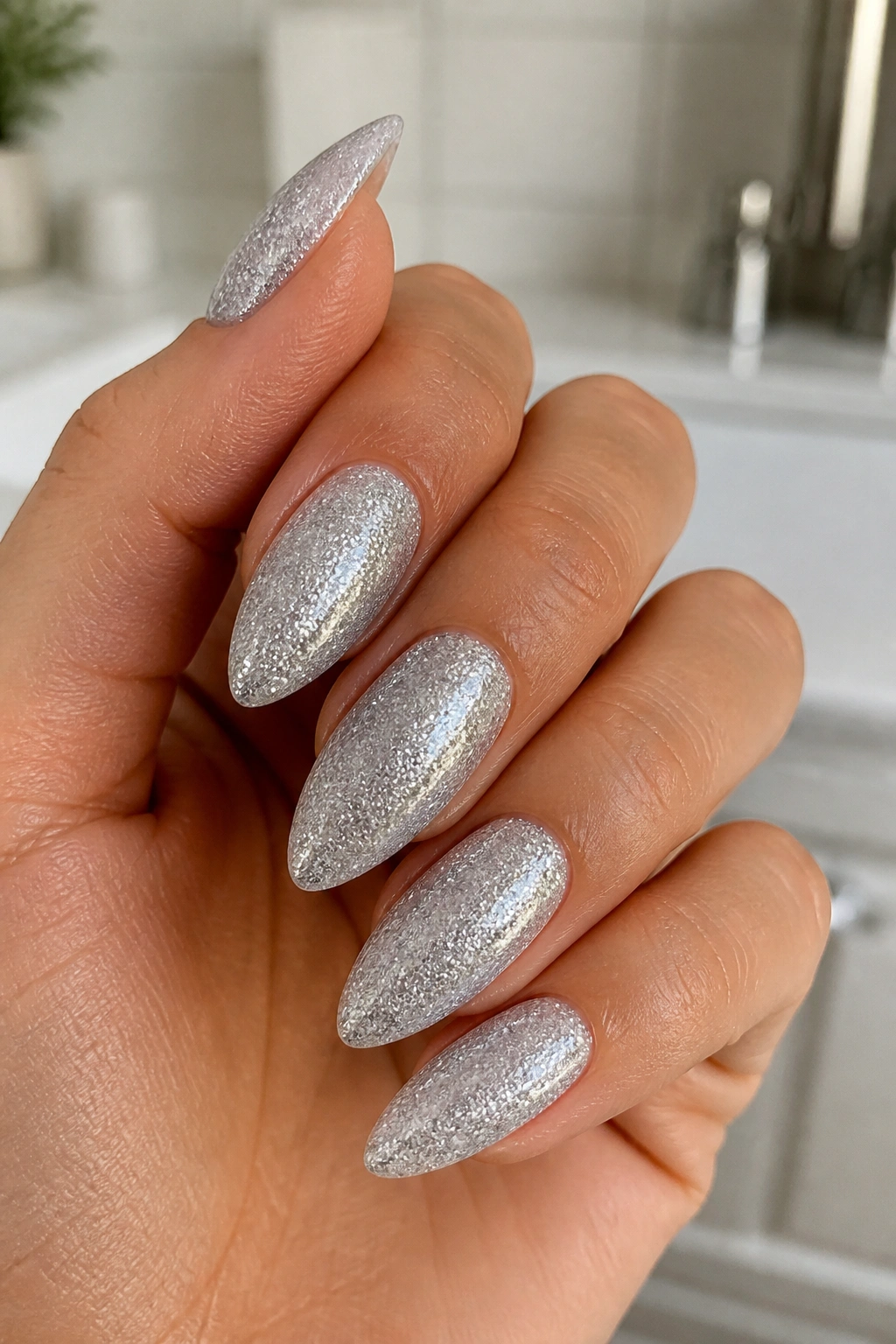 Almond nails with full silver glitter on a neutral base