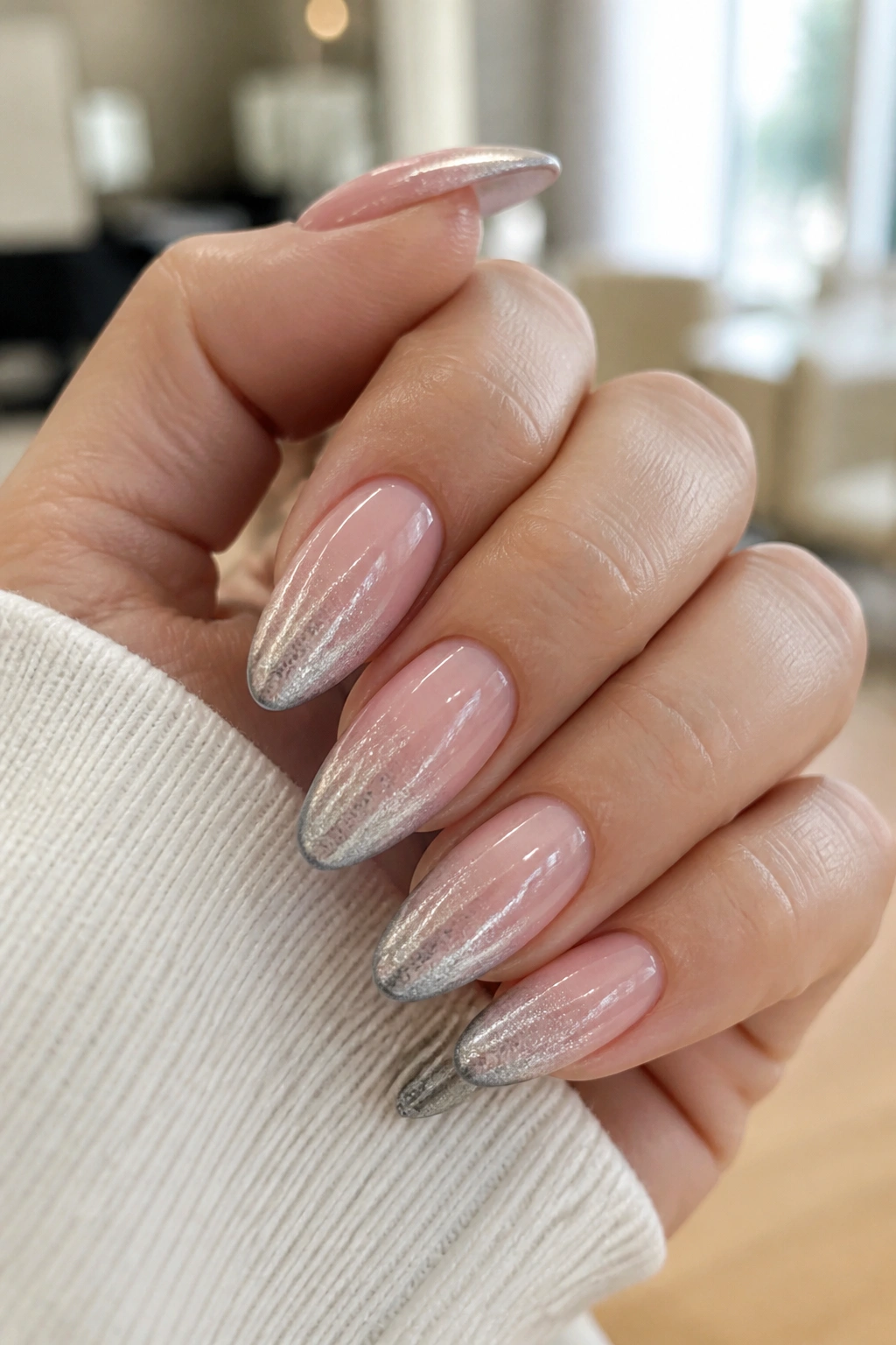 Close-up of almond nails with pink sheer base and silver ombre