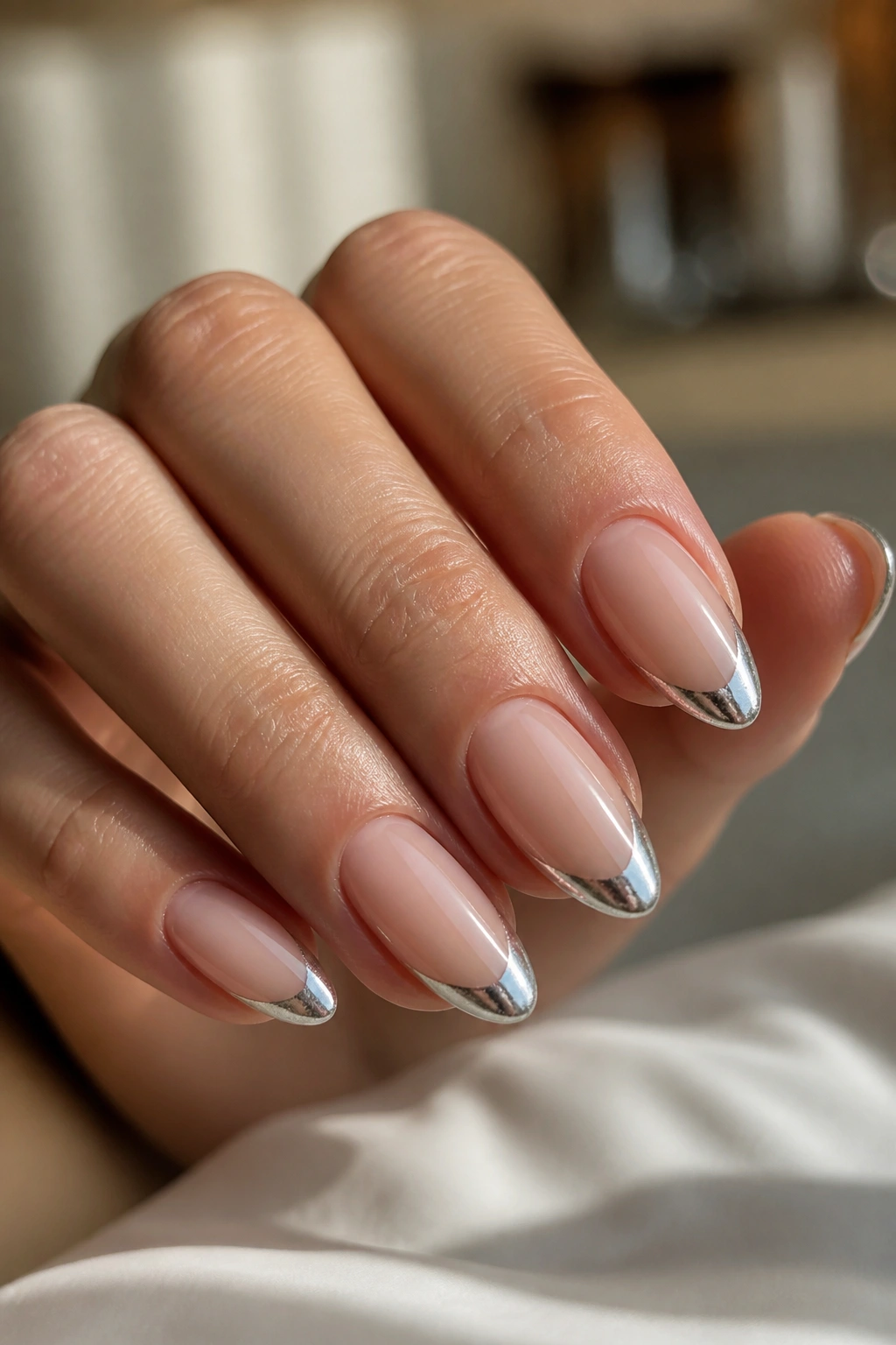 Almond nails with slim silver tips on a nude base