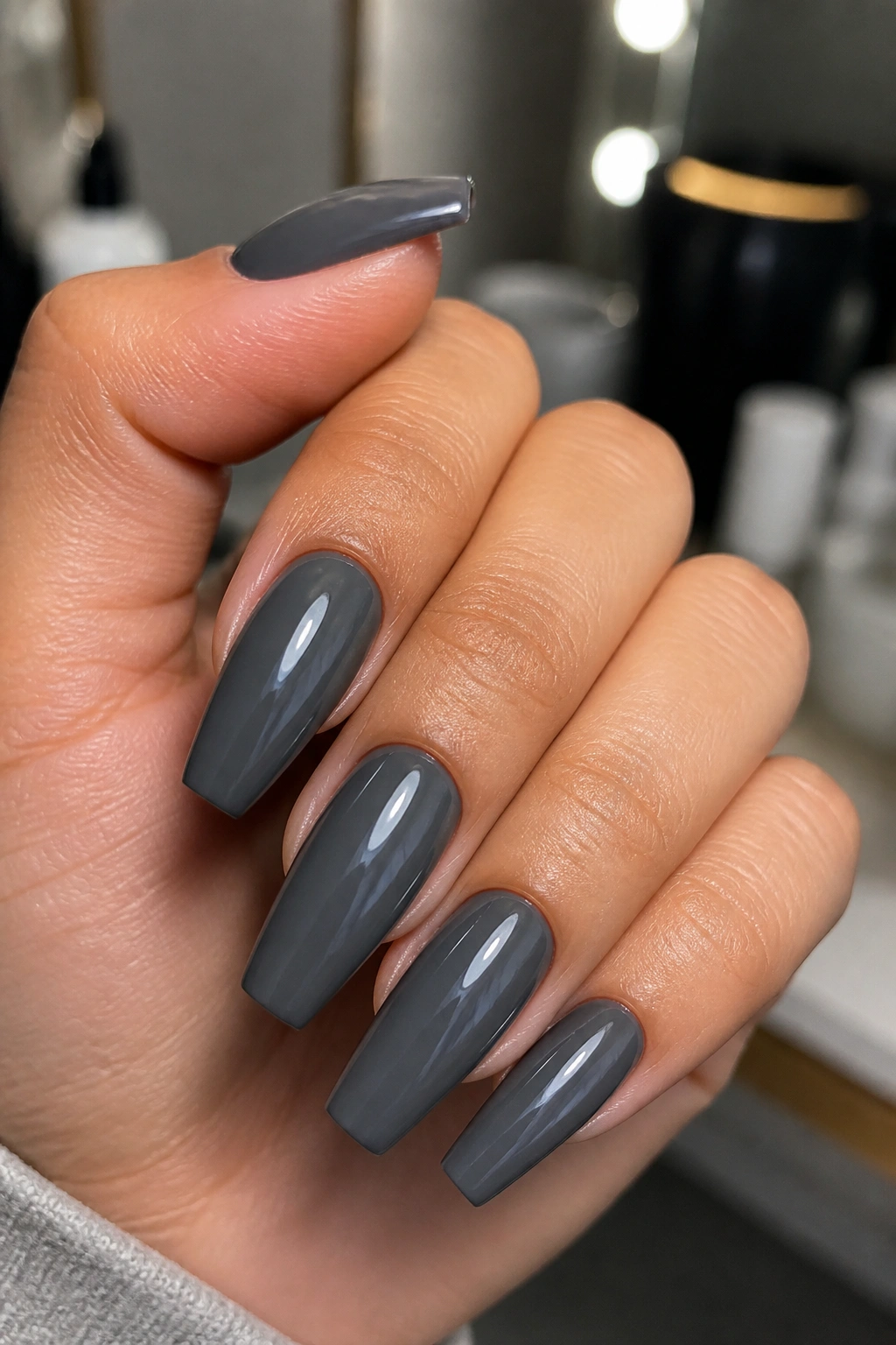 Close-up of a real hand with glossy slate grey coffin nails at medium length
