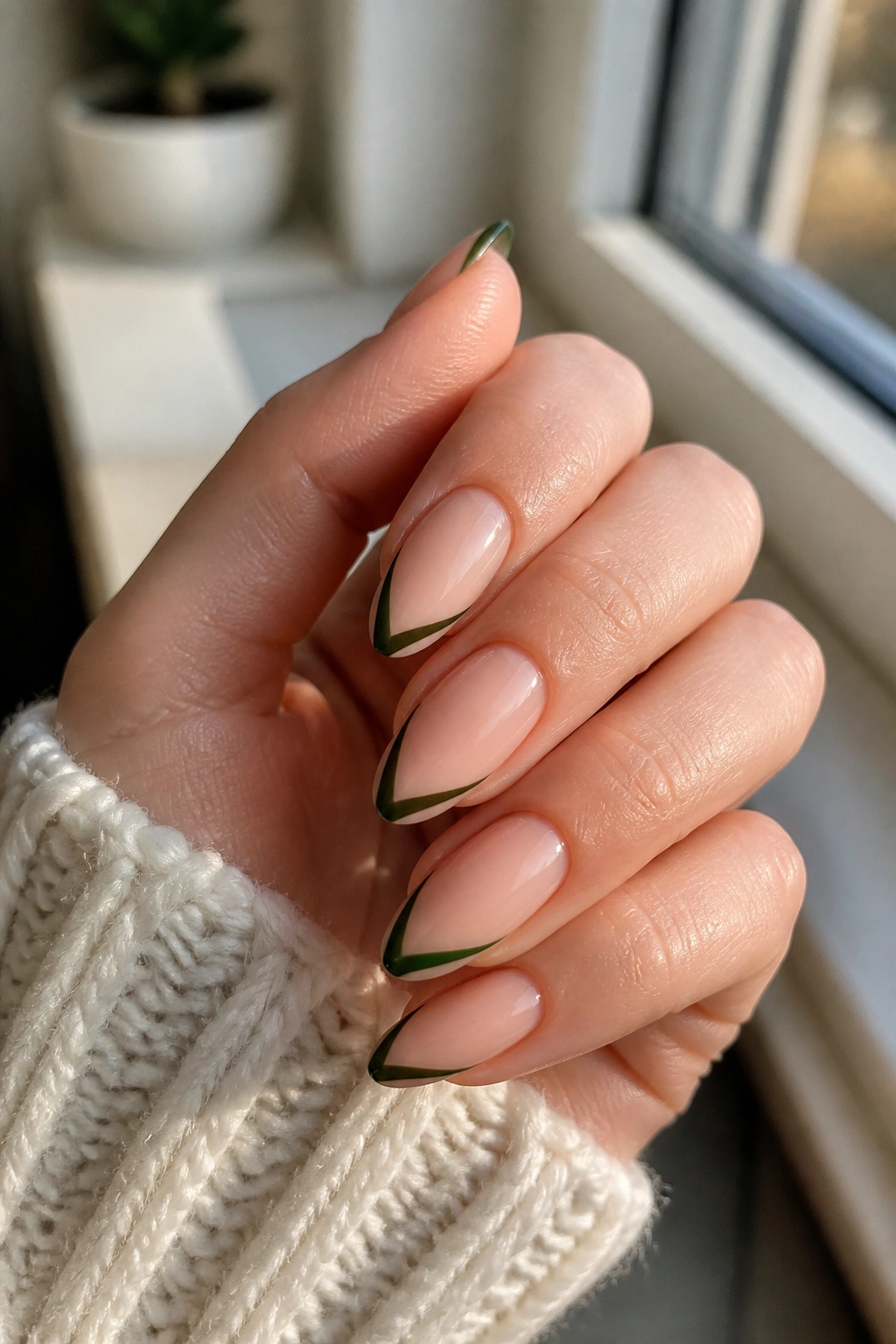 Close-up of slim green French curve almond nails on a real hand