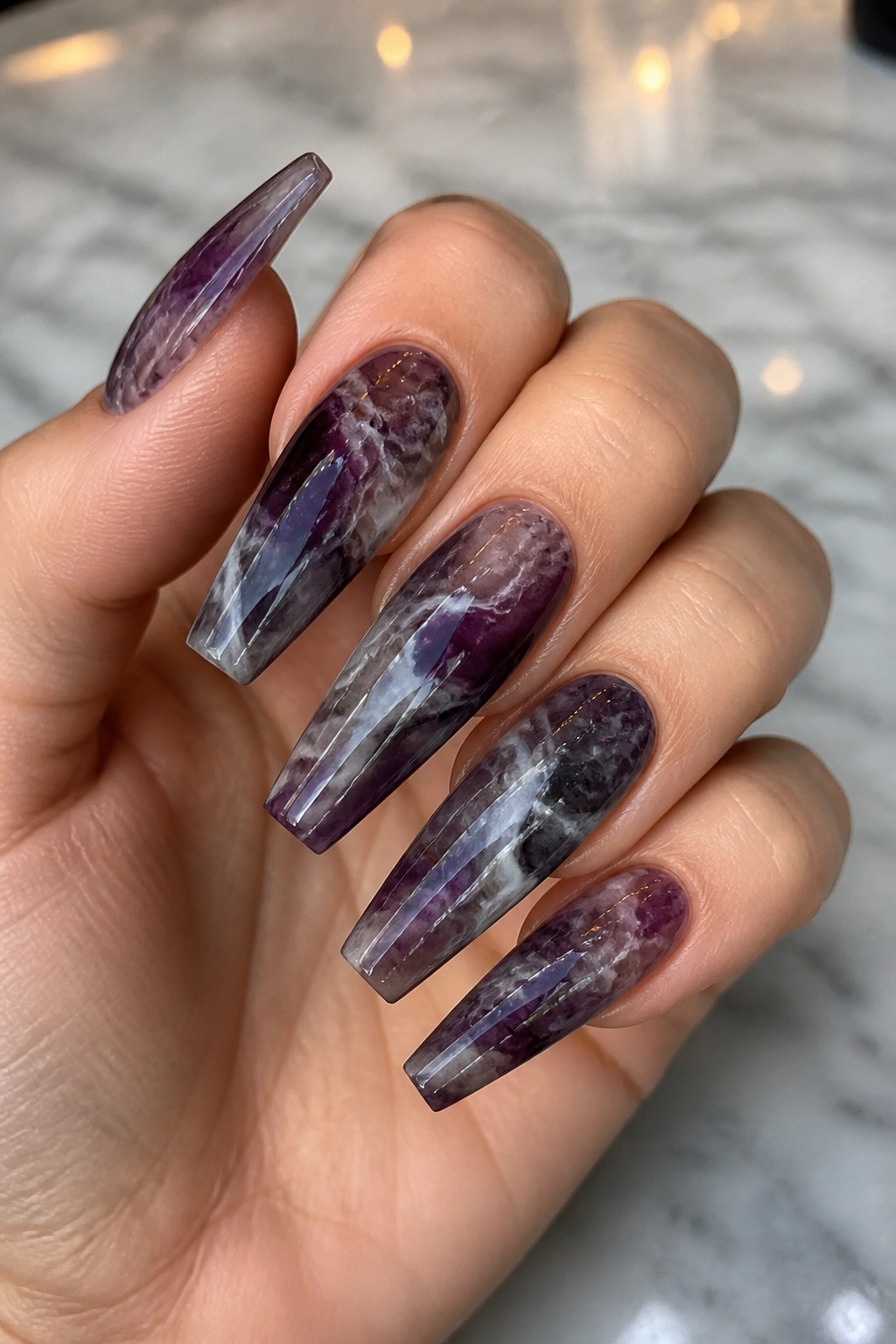 Close-up of smoky amethyst marble coffin nails on a real hand