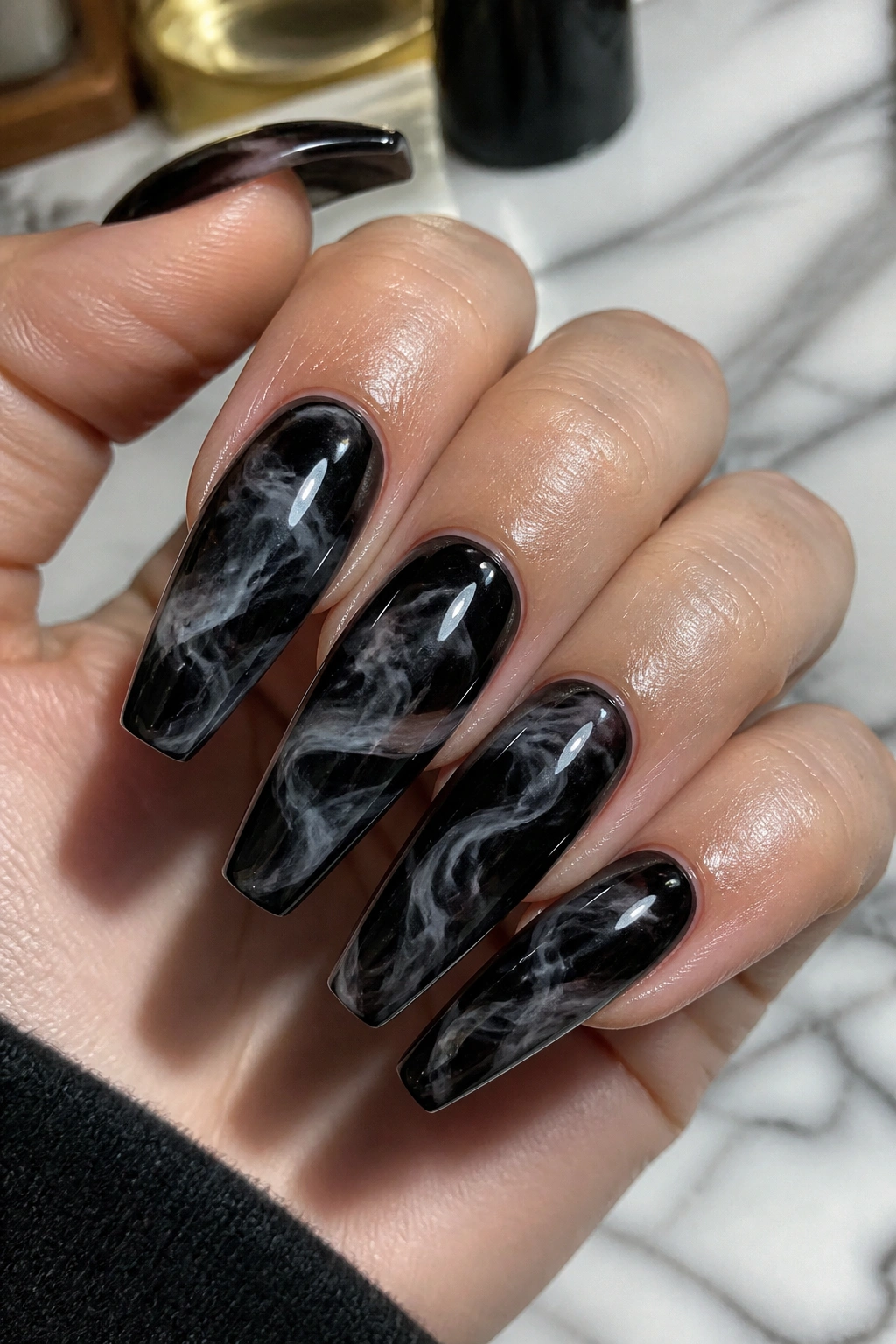 Close-up of smoky marble swirl black coffin nails on a hand.