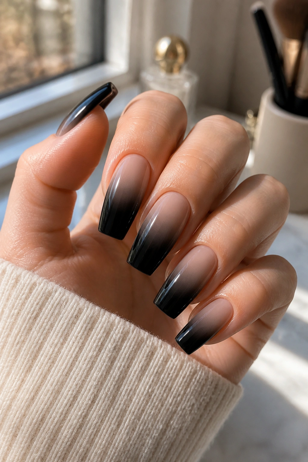 Close-up of smoky ombre coffin nails on a real hand with black-to-nude gradient.