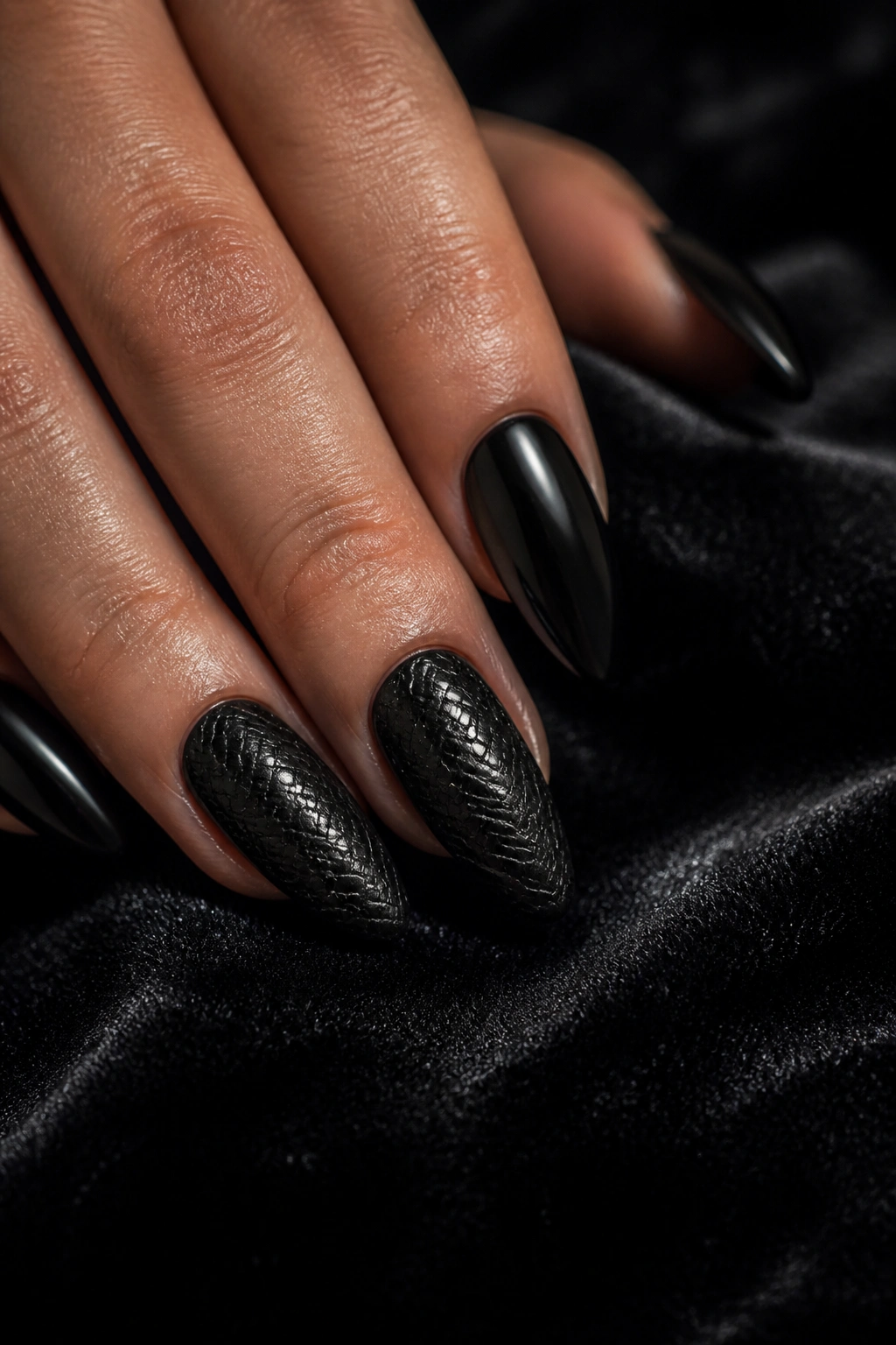 Close-up of almond nails with embossed snakeskin texture on two nails