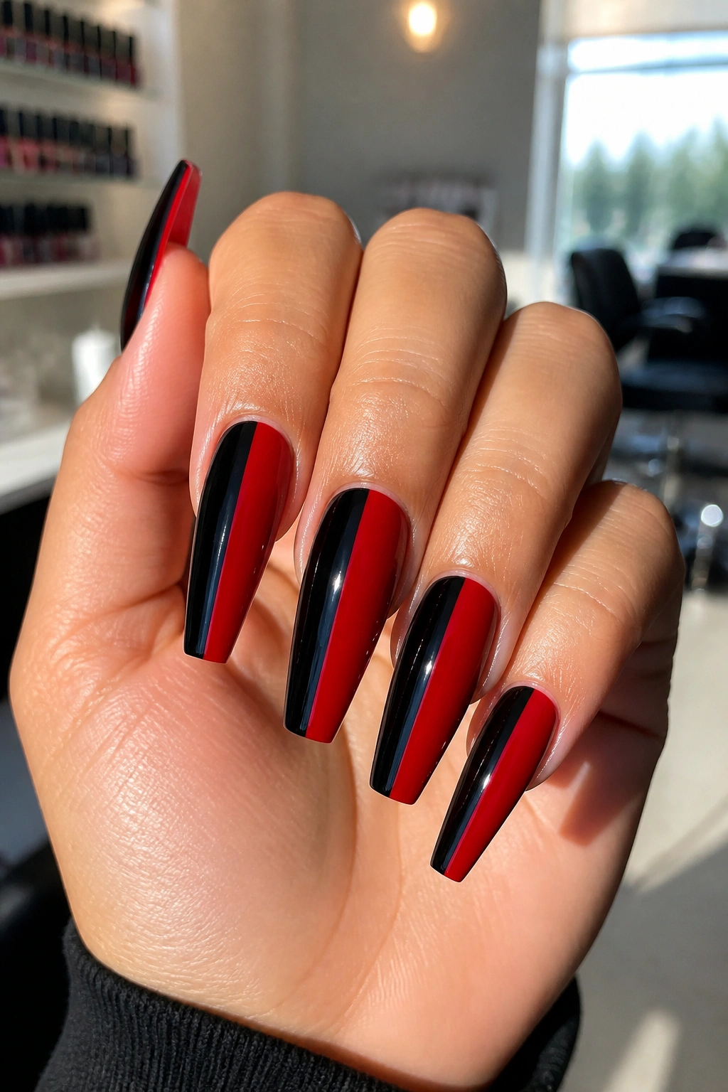 Close-up of split-color red and black coffin nails on a real hand