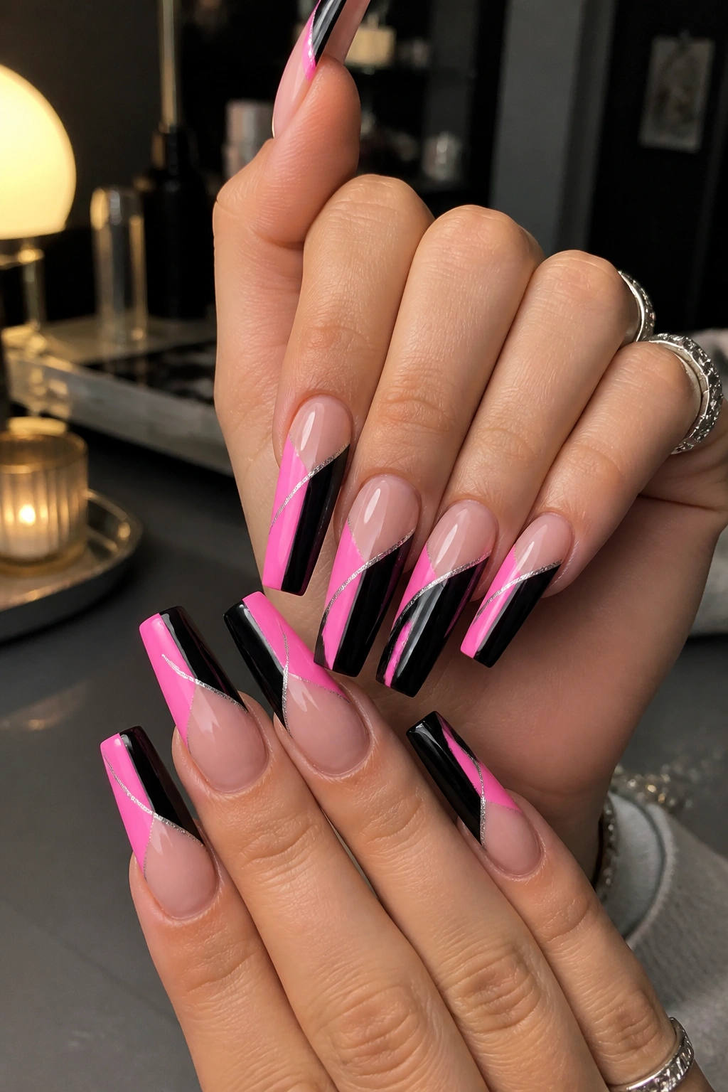 Close-up of black and pink split-tip coffin nails with a silver divider.