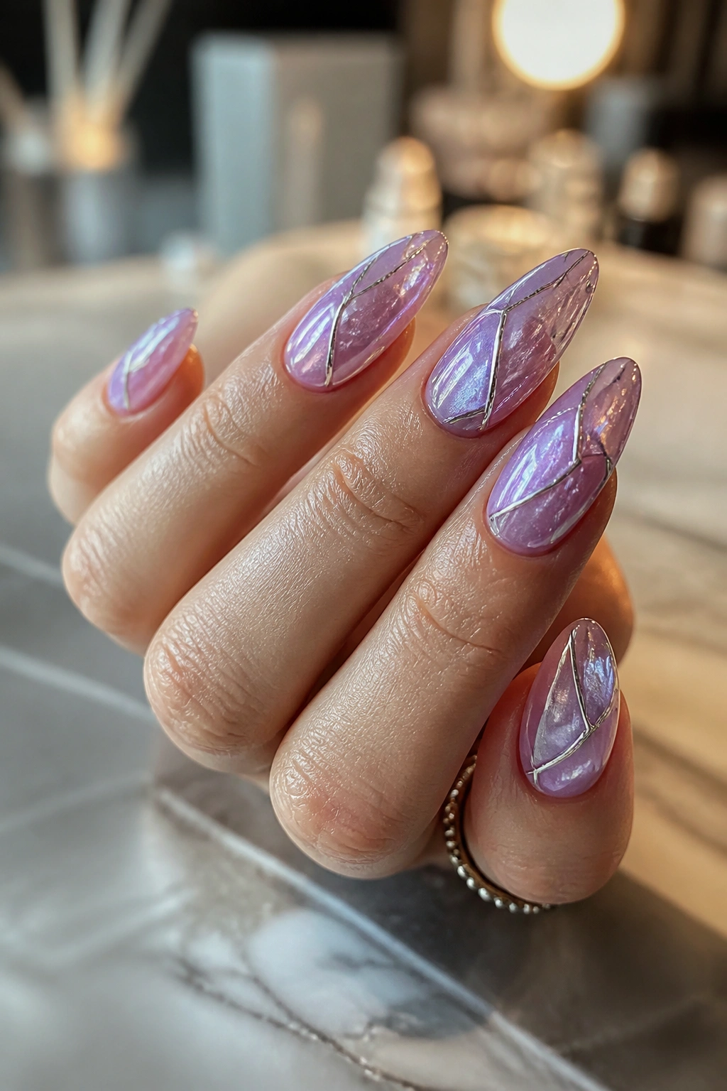 Close-up of long almond nails with stained glass lilac jelly panes on a real hand
