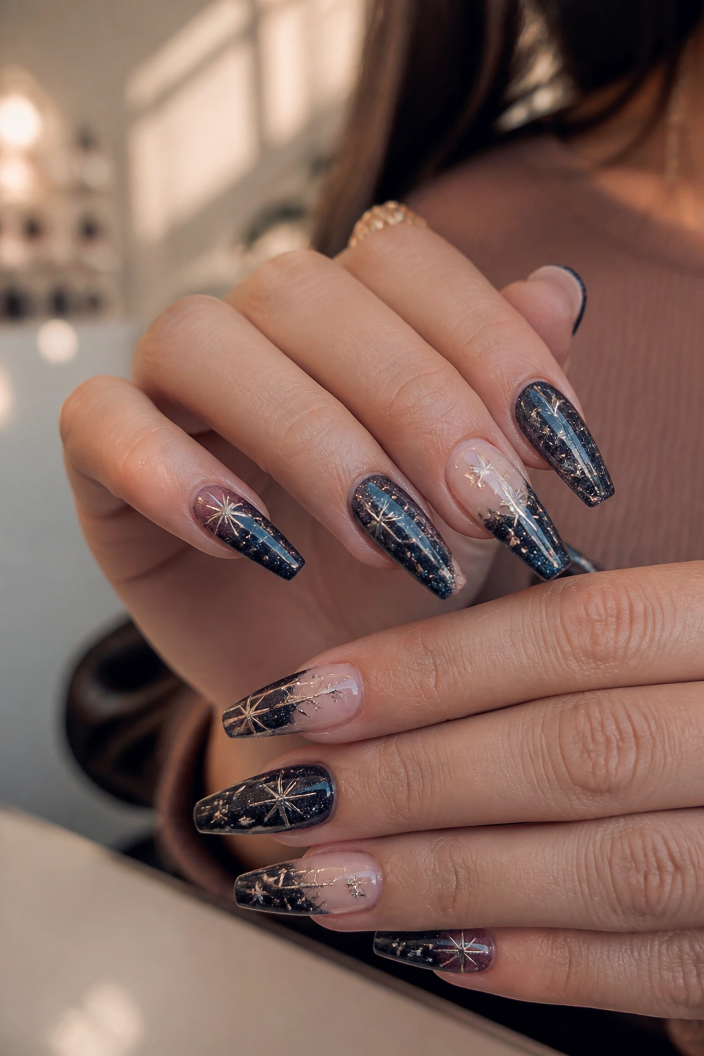 Close-up of real person hands showing star coffin nails on tapered shape in a softly lit salon