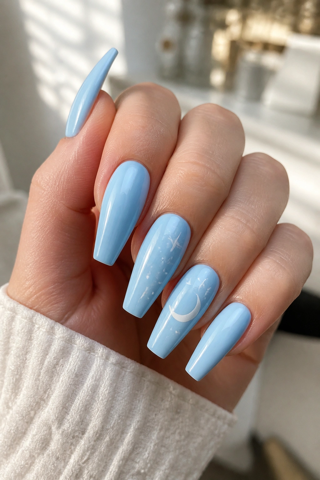 Nails with tiny stars and crescent moons on baby blue coffin nails