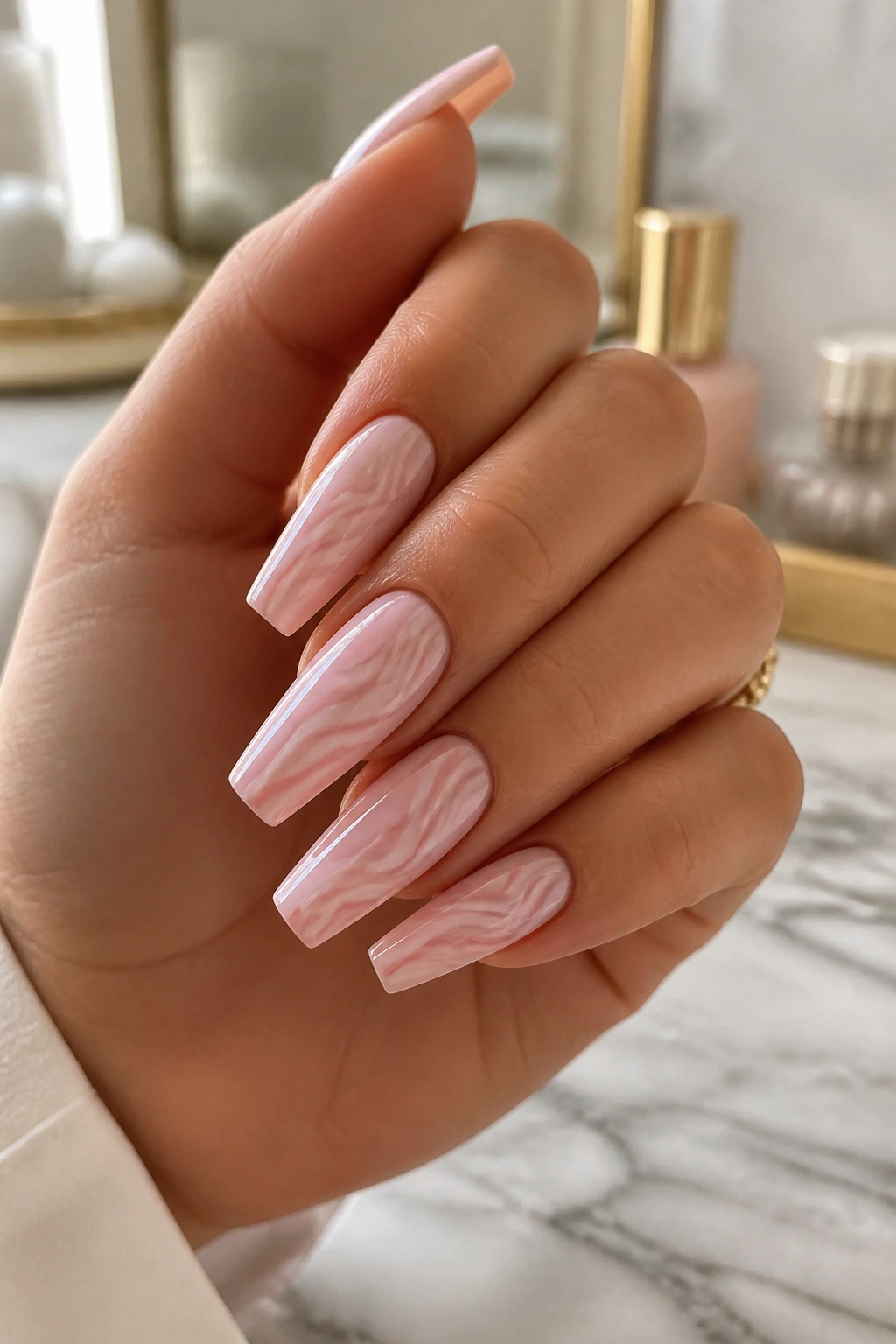 Close-up of tone-on-tone swirl coffin nails with soft blush base and rose swirls