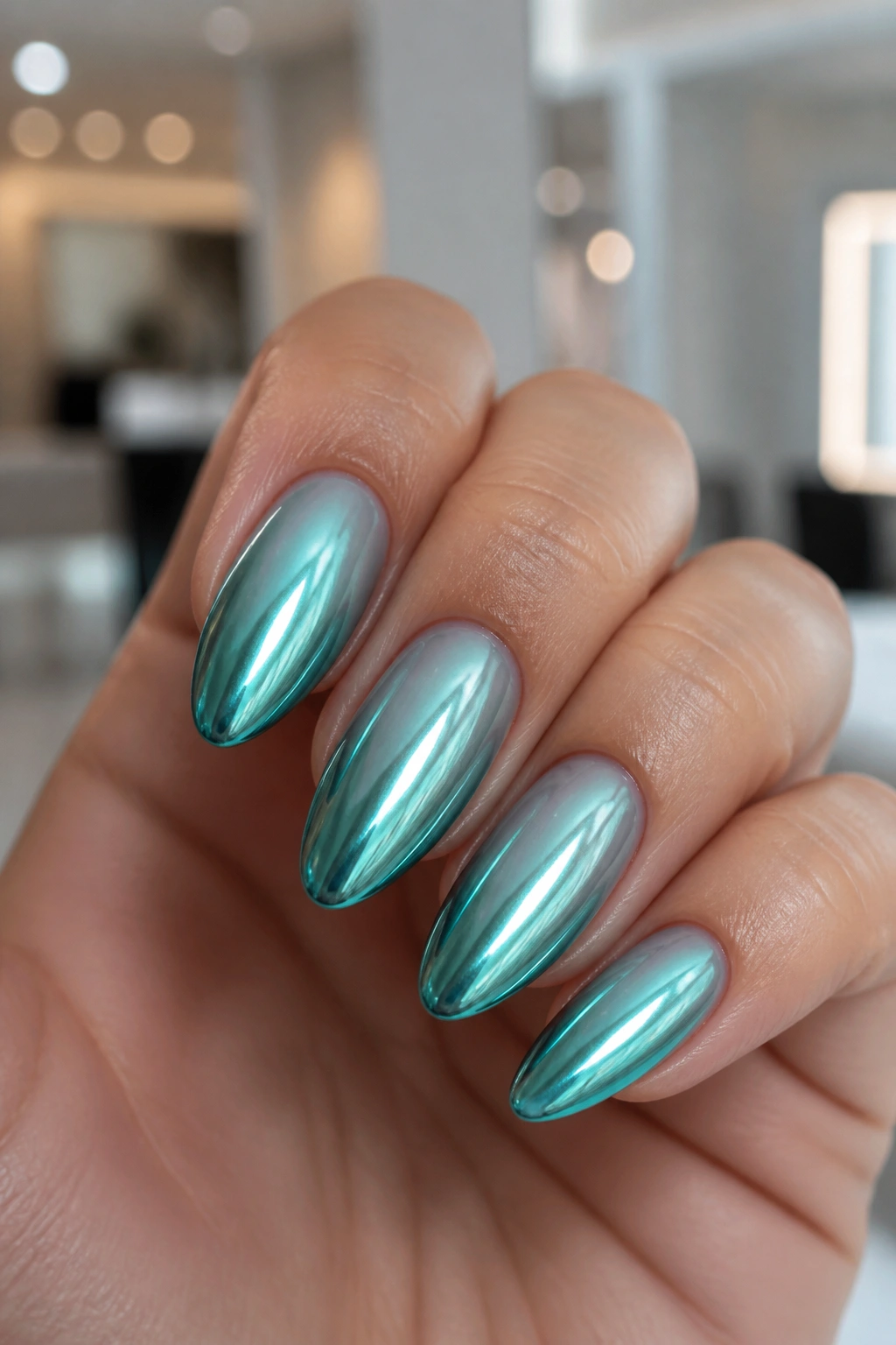 Almond nails with teal chrome over a soft base on real hand