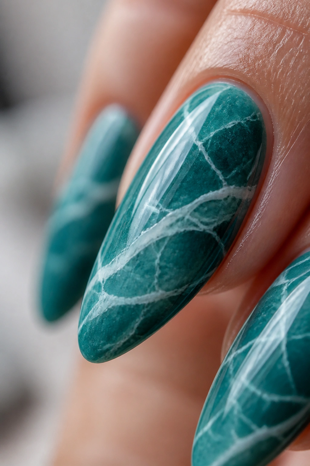 Teal marble nails with white veins on almond nails