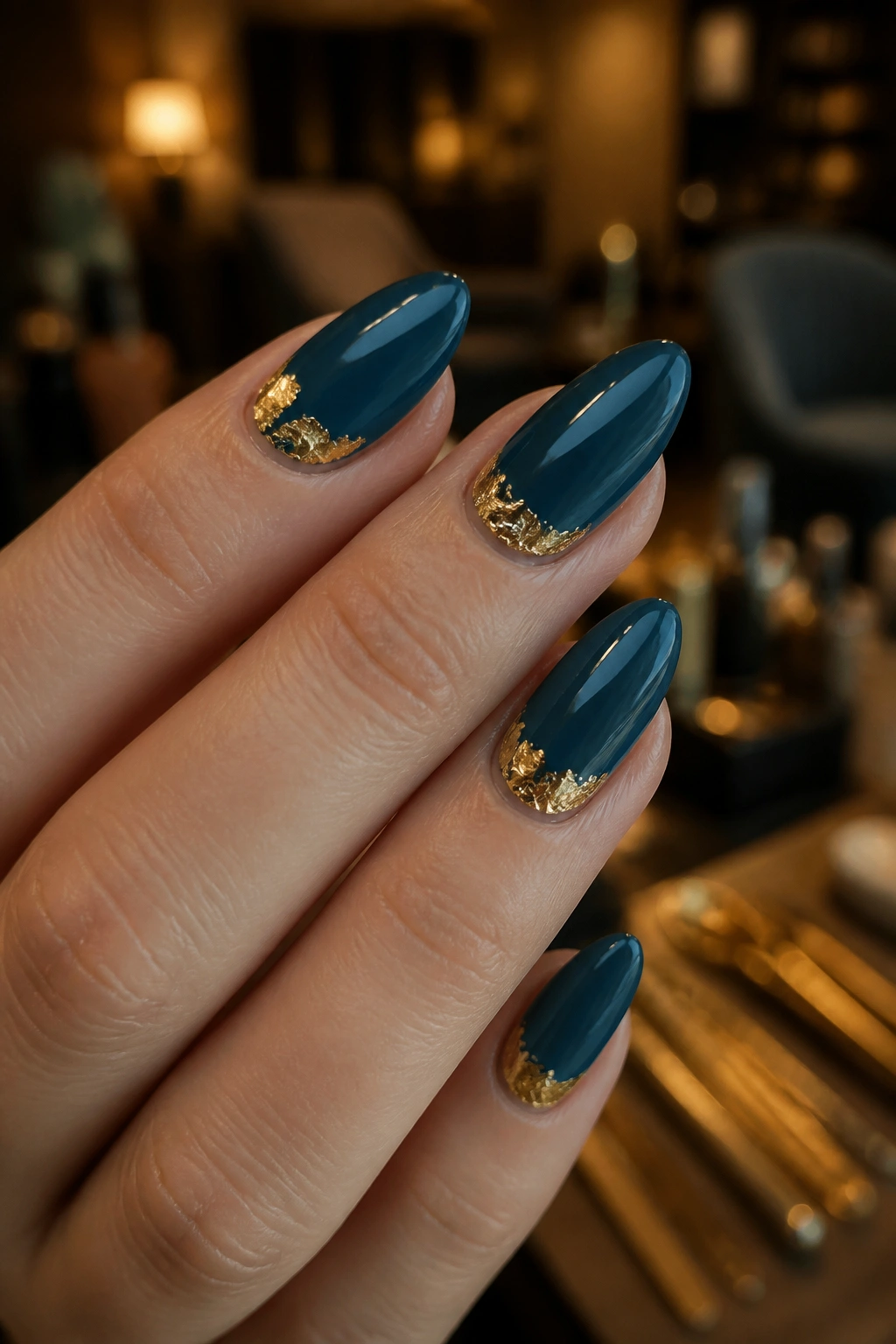 Almond nail with teal base and gold foil near cuticle