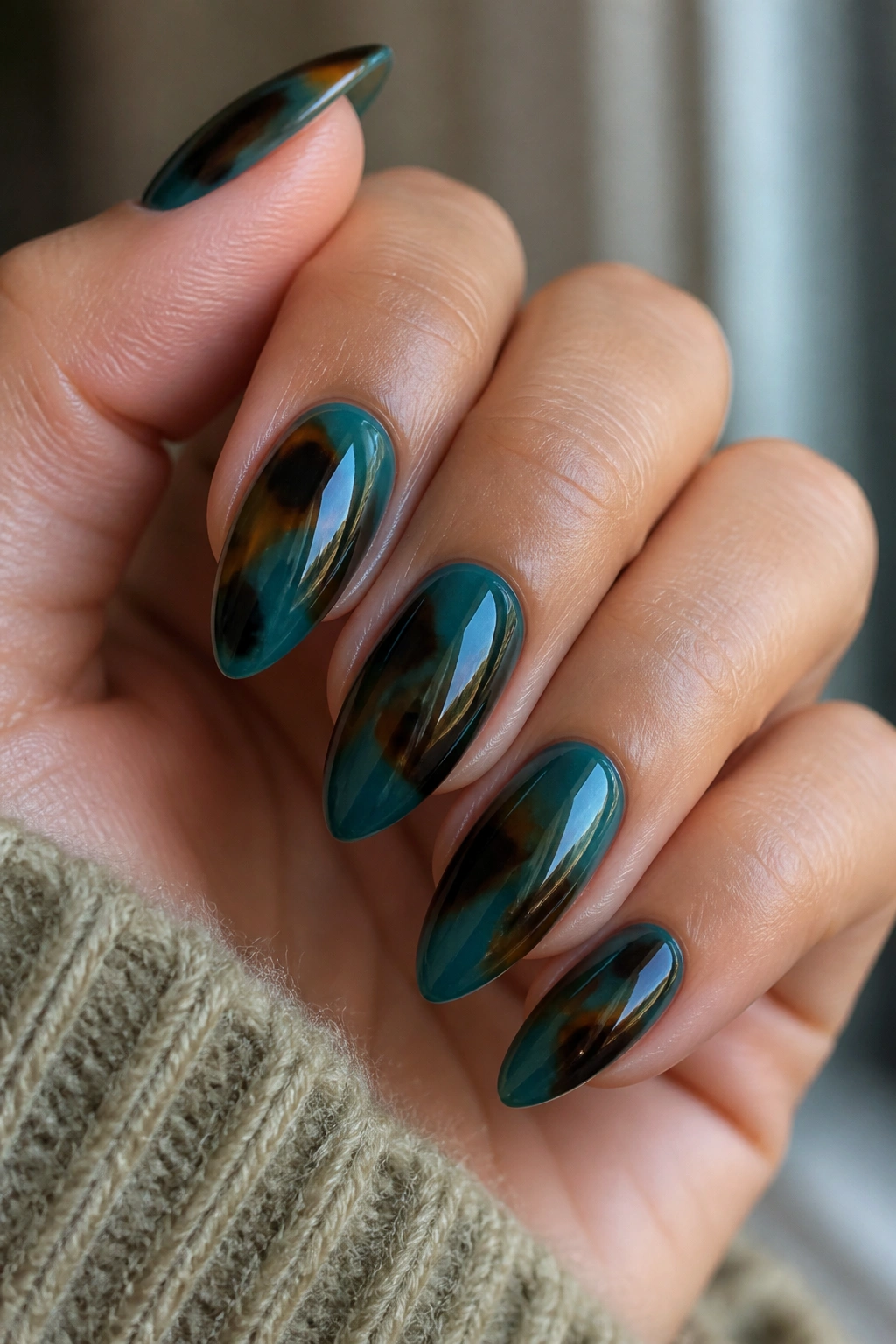 Almond nails in teal tortoiseshell with amber patches on real hand