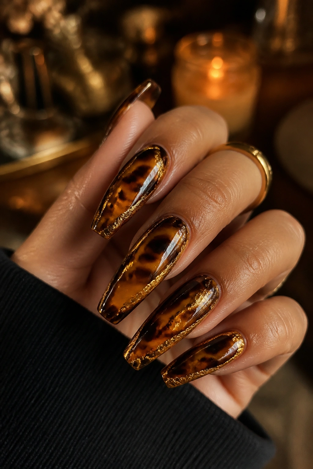 Close-up tortoiseshell coffin nails with gold accents on a real hand