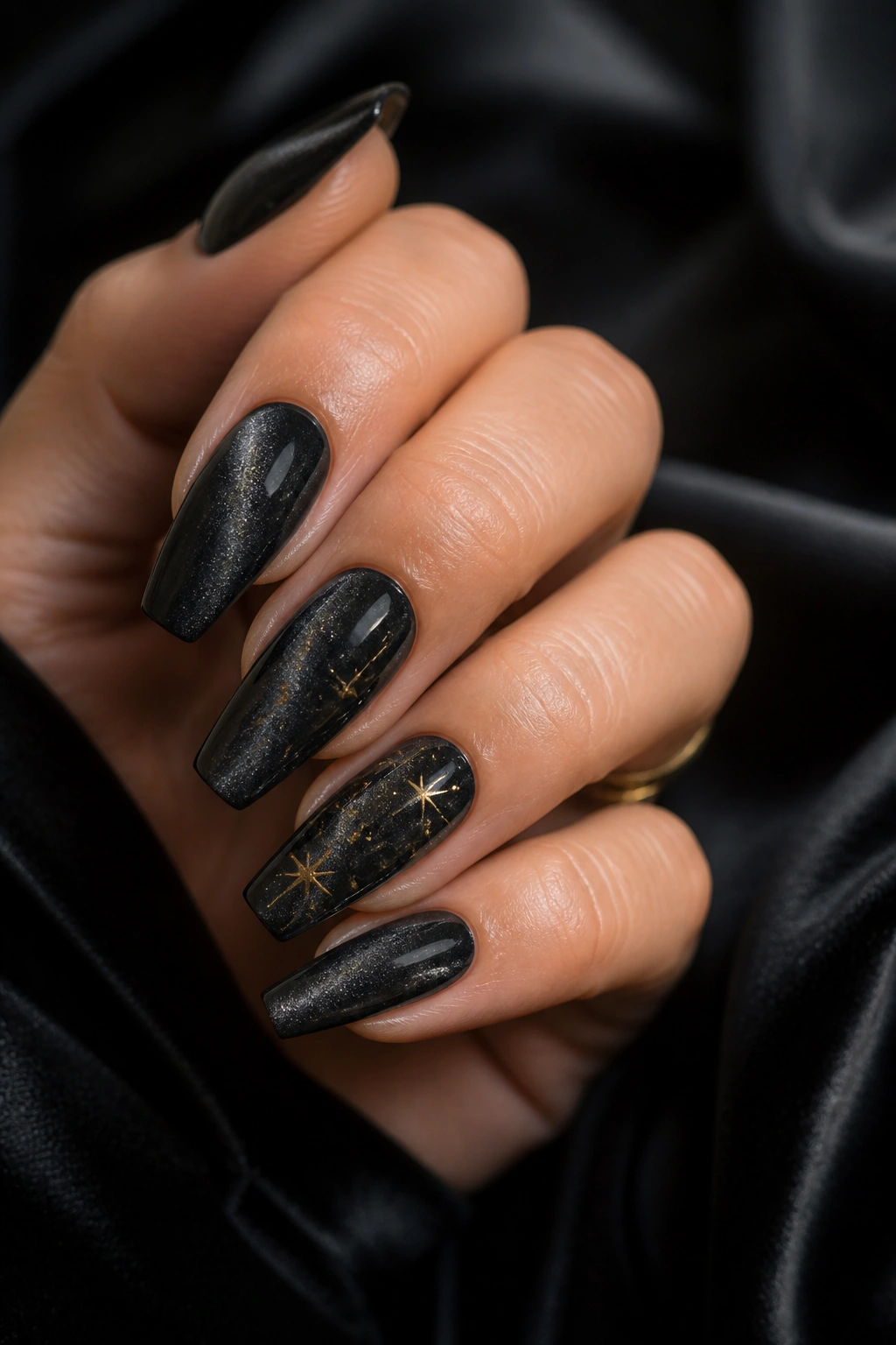 Velvet black coffin nails with tiny gold stars on accent nails
