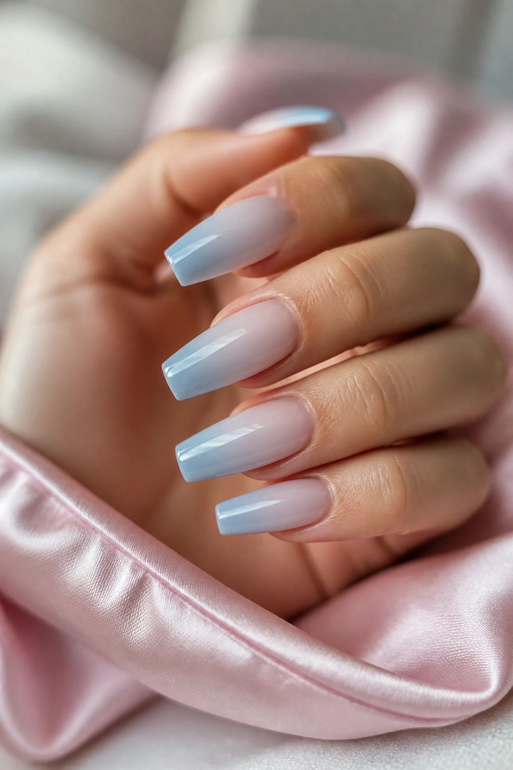 Milky white-to-blue French ombre coffin nails on real hand