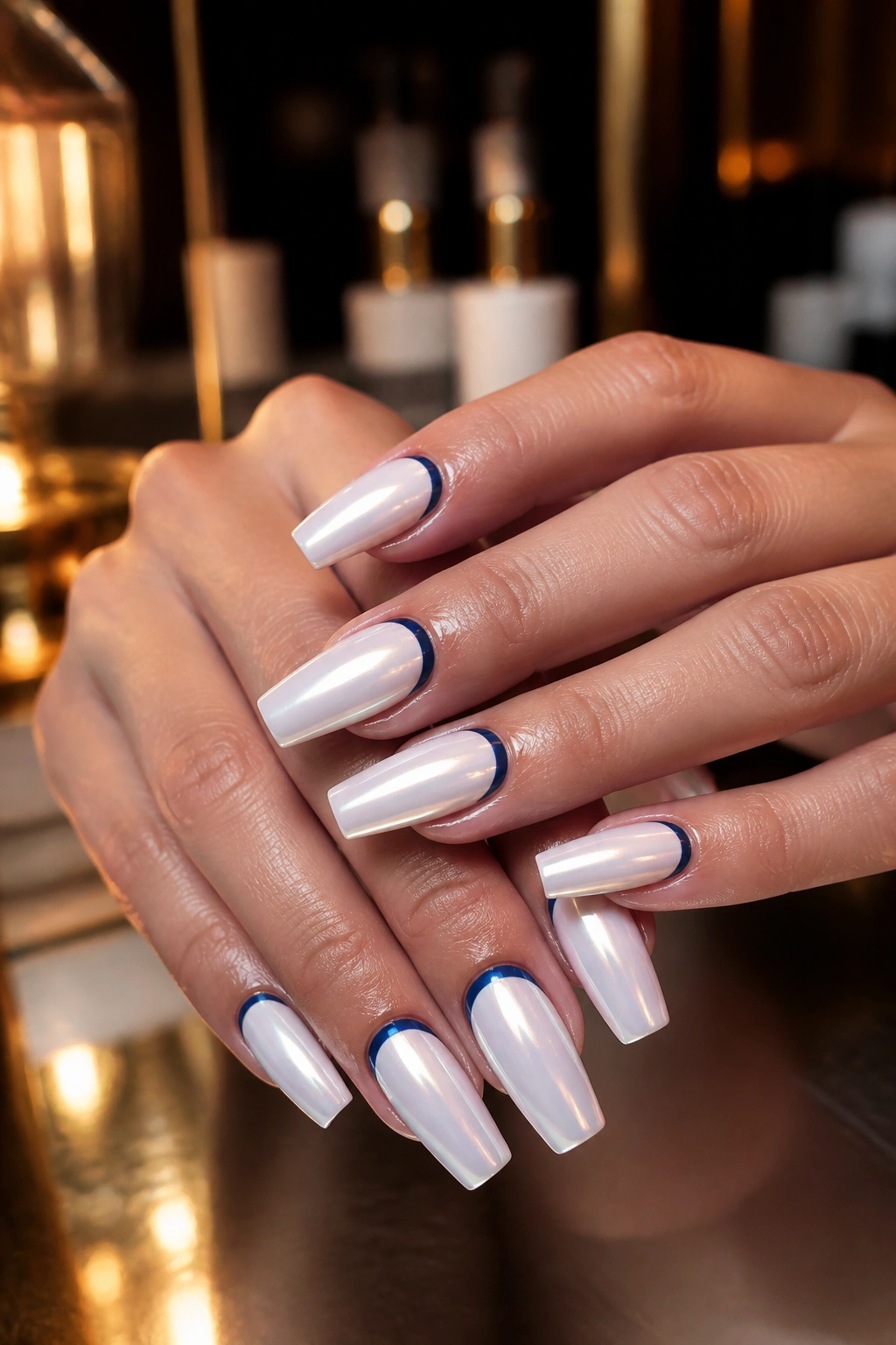 Nails with white chrome finish and dark navy half-moon near cuticle