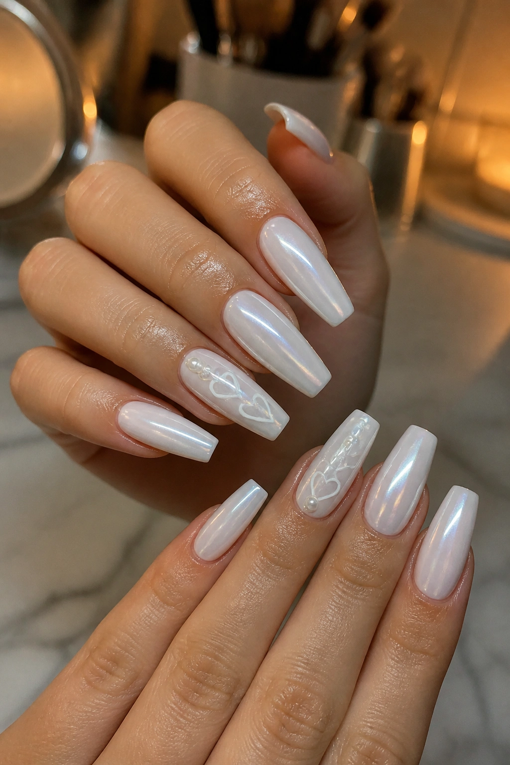 White chrome coffin nails with pearl accents and hearts