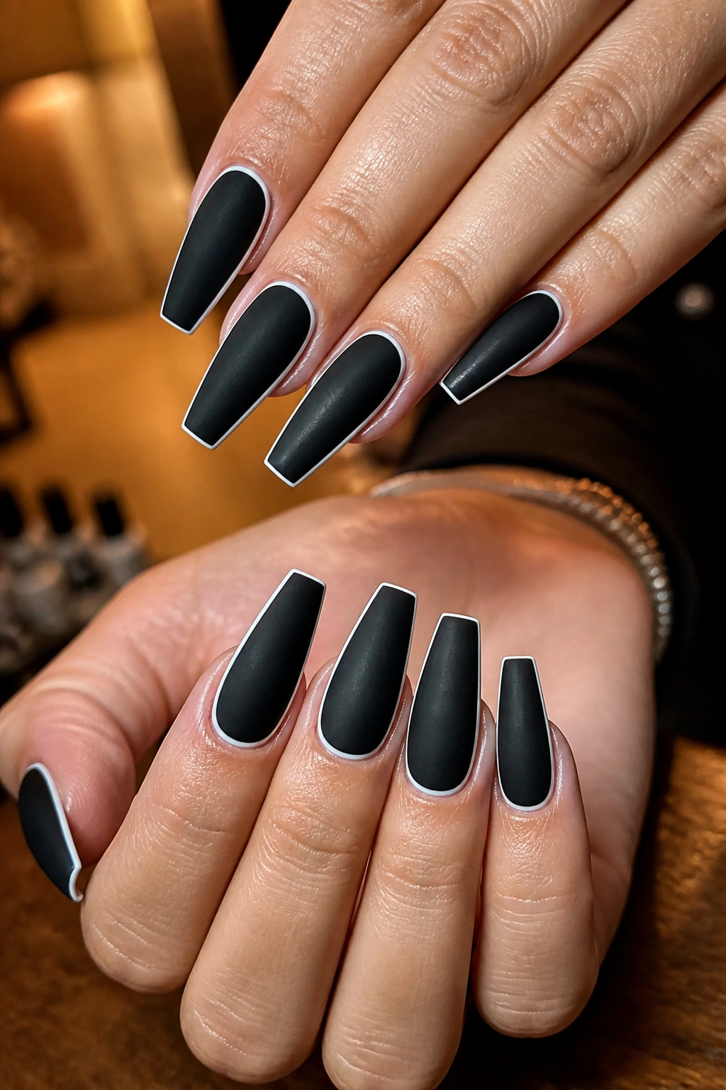 Matte black coffin nails with a thin white outline edges.